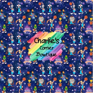 May include: A colourful, rainbow-themed pattern featuring cartoon characters from the movie Space Jam. The characters are playing basketball against a dark blue background with stars. The text "Charlie's Corner Bowtique" is written in a rainbow font.