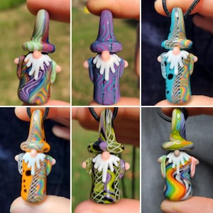 Peut inclure: Six pendentifs en verre en forme de gnome avec une barbe blanche et un motif coloré et tourbillonnant. Chaque pendentif est sur un cordon noir.