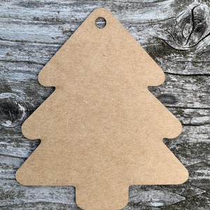 K&ouml;nnte beinhalten: Ein braunes, kartonartiges Etikett in Form eines Weihnachtsbaums mit einem Loch oben.