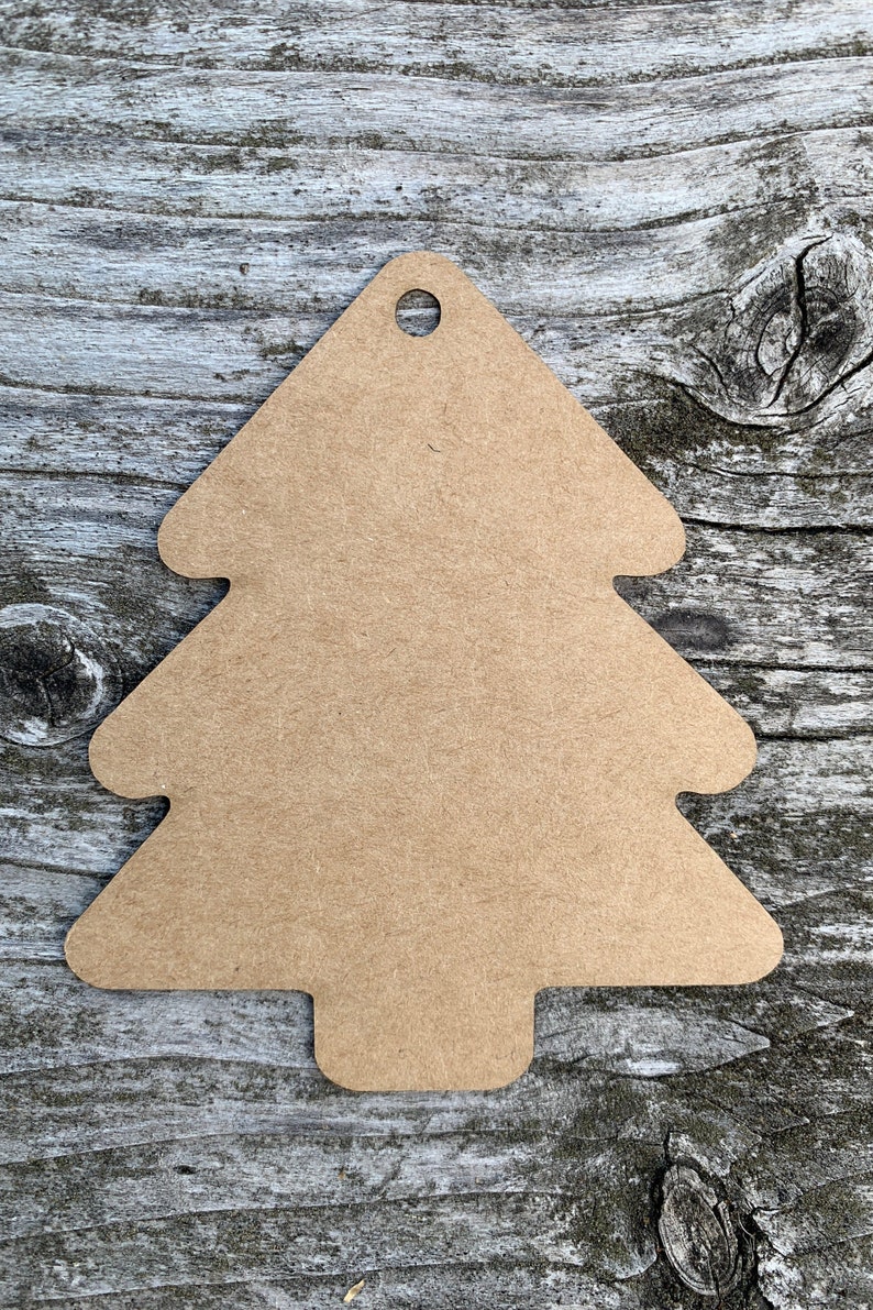K&ouml;nnte beinhalten: Ein braunes, kartonartiges Etikett in Form eines Weihnachtsbaums mit einem Loch oben.