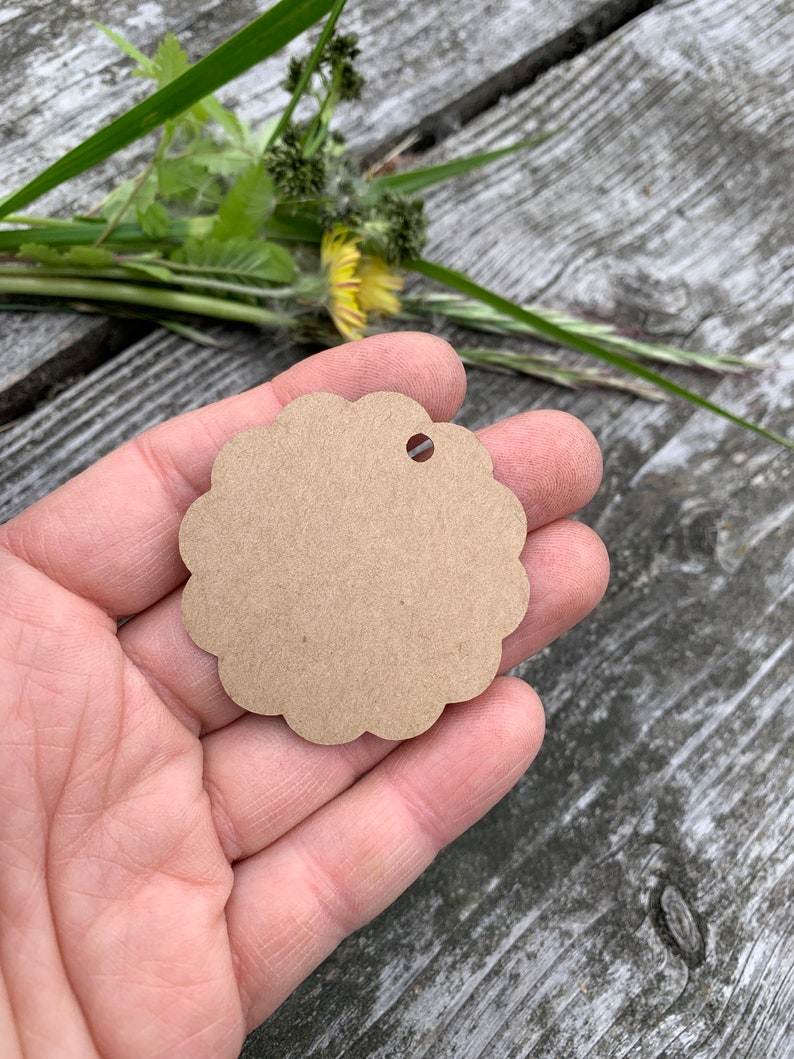 May include: A brown scalloped circle gift tag with a hole punched in the top.