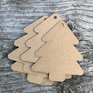 K&ouml;nnte beinhalten: F&uuml;nf braune Papier-Geschenk-Etiketten in Weihnachtsbaumform mit einem Loch oben.