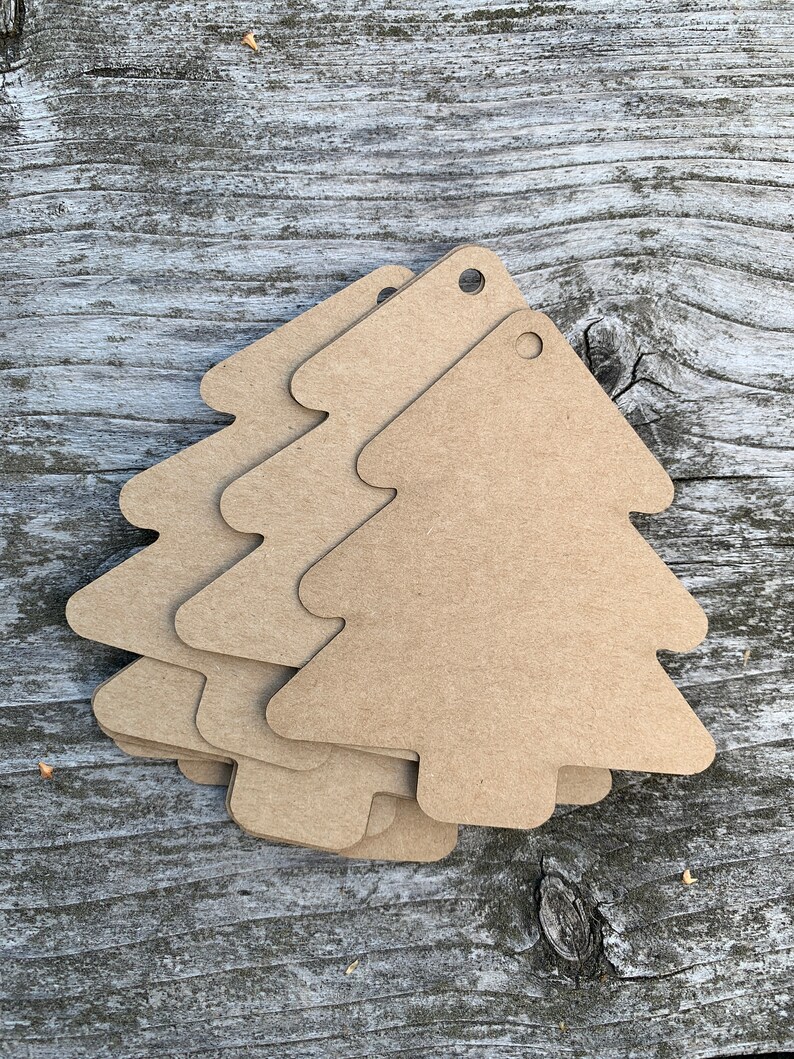 K&ouml;nnte beinhalten: F&uuml;nf braune Papier-Geschenk-Etiketten in Weihnachtsbaumform mit einem Loch oben.
