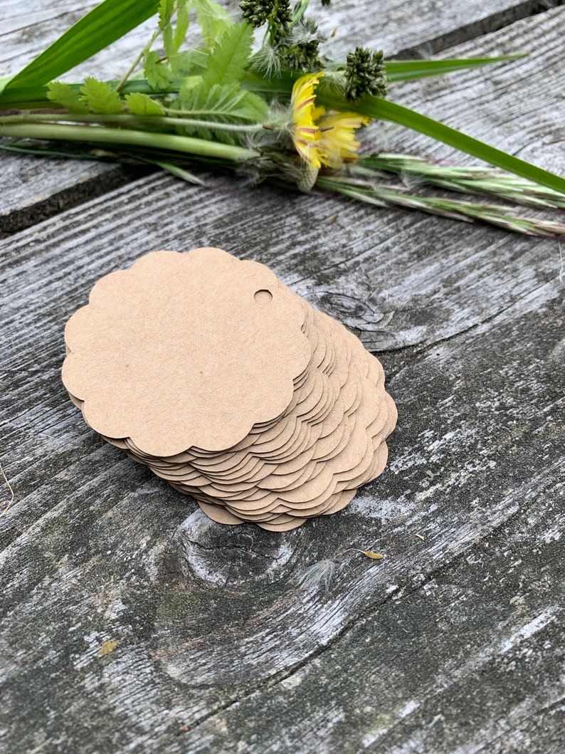 May include: A stack of brown scalloped circle gift tags with a hole punched in the top.