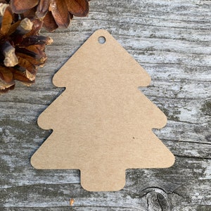 K&ouml;nnte beinhalten: Ein brauner Weihnachtsbaum-Anh&auml;nger aus Papier mit einem Loch oben zum Aufh&auml;ngen.
