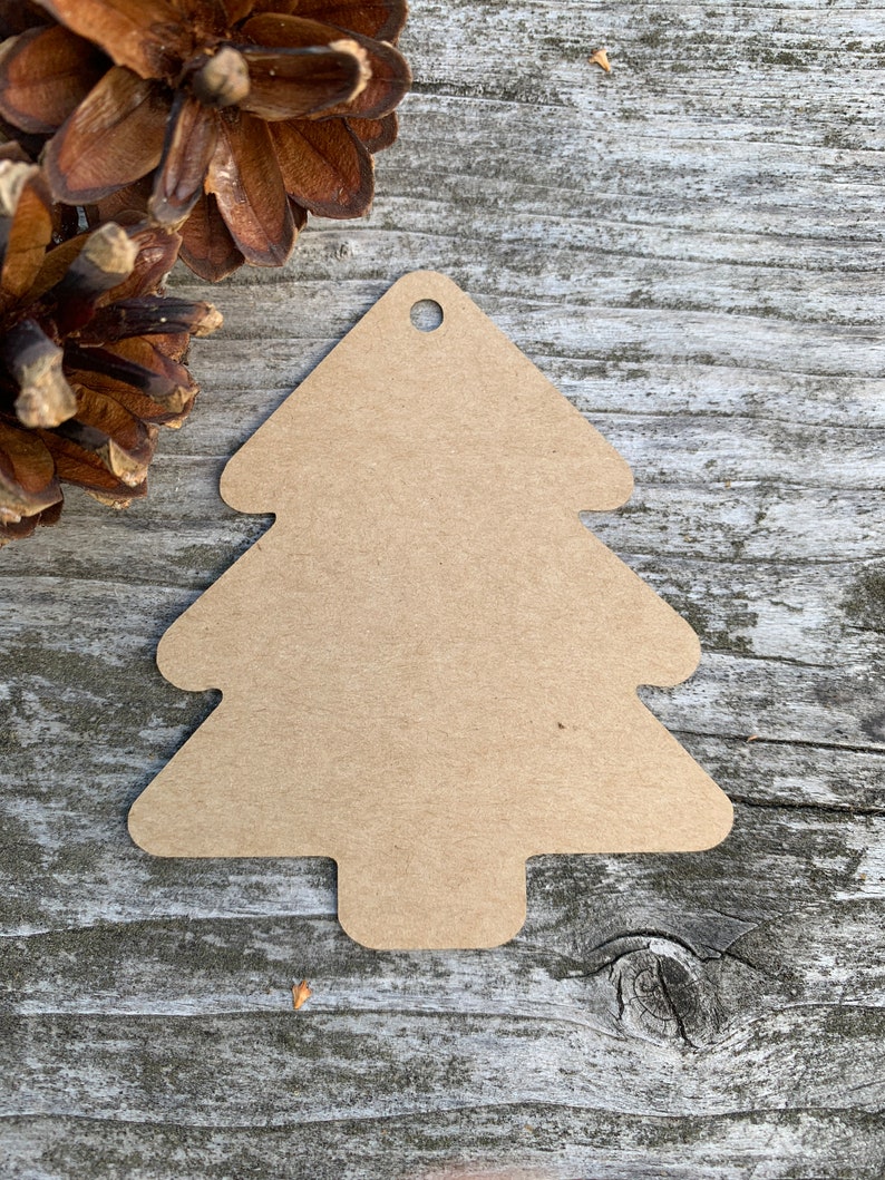 K&ouml;nnte beinhalten: Ein brauner Weihnachtsbaum-Anh&auml;nger aus Papier mit einem Loch oben zum Aufh&auml;ngen.
