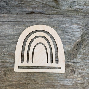 May include: A wooden rainbow cutout with five arches, ideal for crafting or home decor.