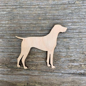 Może przedstawiać: Drewniany wykrój psa w profilu. Wykrój jest jasnobrązowy i ma gładkie wykończenie.