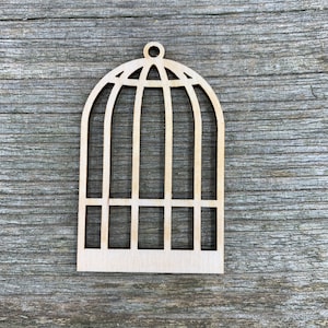 Op de afbeelding: Een houten vogelkooi-uitsparing, perfect voor knutselprojecten. De kooi is gemaakt van lichtbruin hout en heeft een eenvoudig, elegant ontwerp.