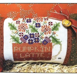 May include: Cross stitch pattern for a cushion featuring a mug with the text "Pumpkin Latte" and a bouquet of flowers. The pattern is designed by Karen Kluba and is part of the Rosewood Manor collection.