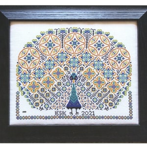 Puede incluir: Un patrón de punto de cruz que presenta un pavo real con una cola colorida, rodeado por un borde de pequeños círculos. El patrón se titula "O' Feathers" y está diseñado por Karen Kluba. El número de patrón es S-1241.