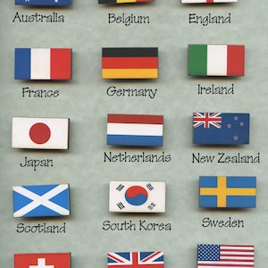 May include: A set of 14 wooden flag magnets featuring the flags of Australia, Belgium, England, France, Germany, Ireland, Japan, Netherlands, New Zealand, Scotland, South Korea, Sweden, Switzerland, and the United Kingdom.