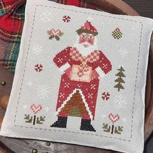 Peut inclure: Modèle de point de croix compté pour un Père Noël en patchwork. Le motif représente un Père Noël rouge et blanc avec une barbe blanche et un sapin de Noël vert. L'arrière-plan est gris clair avec des flocons de neige et des cœurs.
