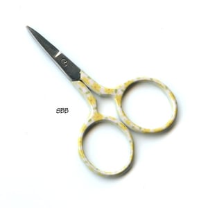 Peut inclure: Petites ciseaux à motifs floraux jaunes et blancs avec des lames argentées.