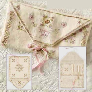 Puede incluir: Un conjunto de tres bolsas de aguja de tela blanca con bordado floral. Las bolsas se cierran con una cinta rosa y tienen un pequeño bolsillo en la parte delantera. Las bolsas son perfectas para guardar agujas, hilo y otros pequeños accesorios de costura.