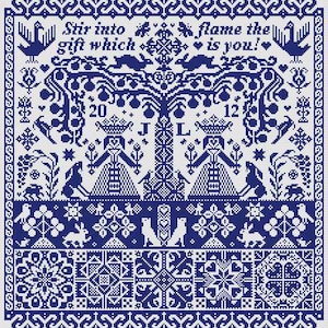 May include: A blue and white cross-stitch sampler featuring a central tree, two figures, rabbits, birds, and geometric borders. The text reads: Stir into flame the gift which is you! The design includes the numbers 20 and 12 and the letters J and L.