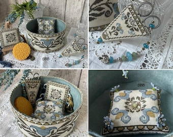 May include: A blue and white needlepoint box with a floral design and a blue and white needlepoint pillow inside. The box is filled with various needlepoint projects, including a small blue and white needlepoint pillow, a blue and white needlepoint pincushion, and a blue and white needlepoint scissor case. The box is sitting on a white surface.