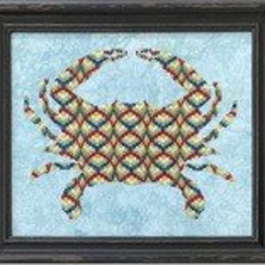 May include: A framed cross-stitch embroidery of a crab with a colorful geometric pattern on a light blue background.