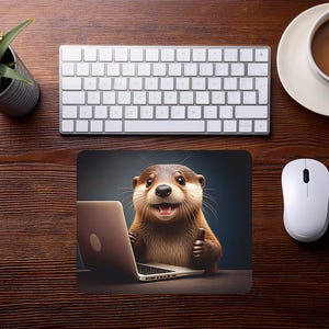 Könnte beinhalten: Ein Mauspad mit einem Cartoon-Otter, der einen Laptop benutzt und einen Daumen hoch zeigt. Das Bild befindet sich auf einem Holztisch mit einer weißen Tastatur, einer Maus und einer Tasse Kaffee. Eine kleine Topfpflanze ist ebenfalls zu sehen.