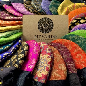 May include: A collection of colourful, patterned fabric pouches with gold accents. The pouches are arranged in a circle around a card with the text "MYVARDO GYPSYSOUL".