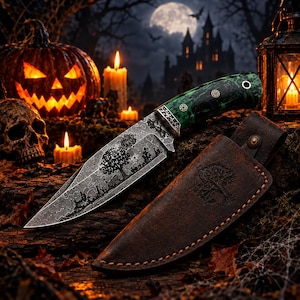 May include: A fixed-blade knife with a patterned metal blade featuring an etched tree and landscape design. The handle is green with a marbled texture and silver rivets. It includes a brown leather sheath embossed with a tree emblem.