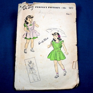 May include: Vintage Du Barry Perfect Pattern 5672, featuring illustrations of a little girl in dresses. The pattern includes the text "Easily-Made" and "Size 1". The illustrations show the girl in different dresses, including one with an umbrella.