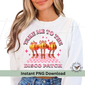 Może przedstawiać: Biała bluza z napisem "Take Me To The Disco Patch" w różowych literach. Projekt przedstawia trzy kreskówkowe dynie w złotych butach i różowych sukienkach.