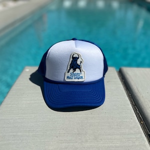 Parche de licor de malta Schlitz vintage en un sombrero de camionero de malla blanca y azul