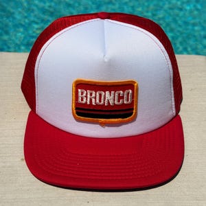 Vintage Ford Bronco Logo Patch on a White and Red Mesh Adjustable Trucker Hat