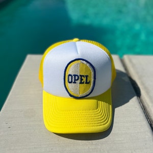 Vintage Opel Motors Logo Patch on a White and Yellow Mesh Trucker Hat