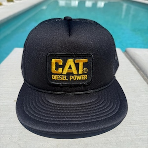 Vintage Caterpillar Diesel Power-logopatch op een zwarte mesh-truckerhoed