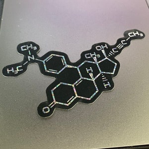 May include: A black and white chemical structure sticker with a holographic finish. The sticker features a complex molecule with the chemical formula CH3, OH, and H.