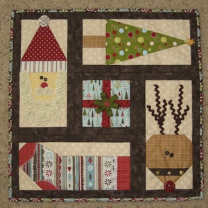 May include: A brown and white patchwork quilt with a Christmas theme. The quilt features a Santa Claus, a Christmas tree, a reindeer, and a gift box. The quilt is made with a variety of fabrics, including red, green, and white.