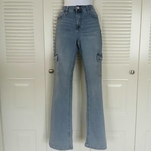 May include: Light blue denim cargo pants with a straight leg fit and two large cargo pockets on each leg.