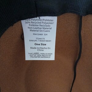May include: A close-up of a hat's interior, featuring a brown fabric and a black brim. A white label displays text including "70% Polyester", "One Size", and "Made In China". The label also states the yarn is made of 100% recycled polyester materials.