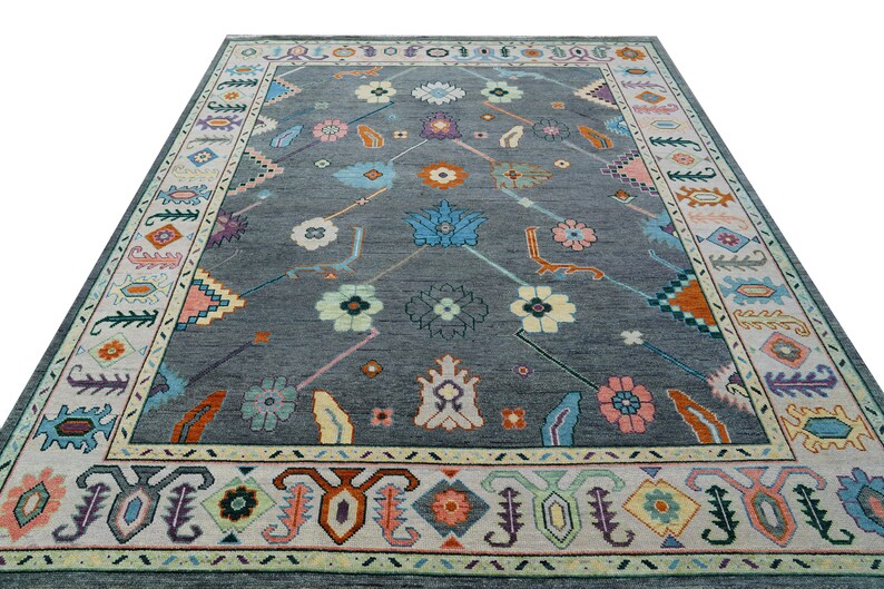 Hand-knotted wool rug in floral Turkish Oushak style, 8x10; blue-gray field with teal, rust, and peach blossoms.