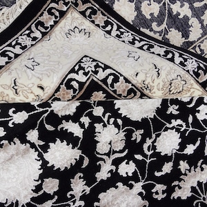 A 5.5x7.9 ft hand-knotted rug featuring a large, ornate ivory and blue central medallion on a deep navy blue field. The field is filled with intricate scrolling vines and small floral motifs. A wide, multi-layered border in ivory and light blue frames the rug. The rug is made of wool with silk highlights that give it a subtle sheen, finished with a short white fringe at the top and bottom.