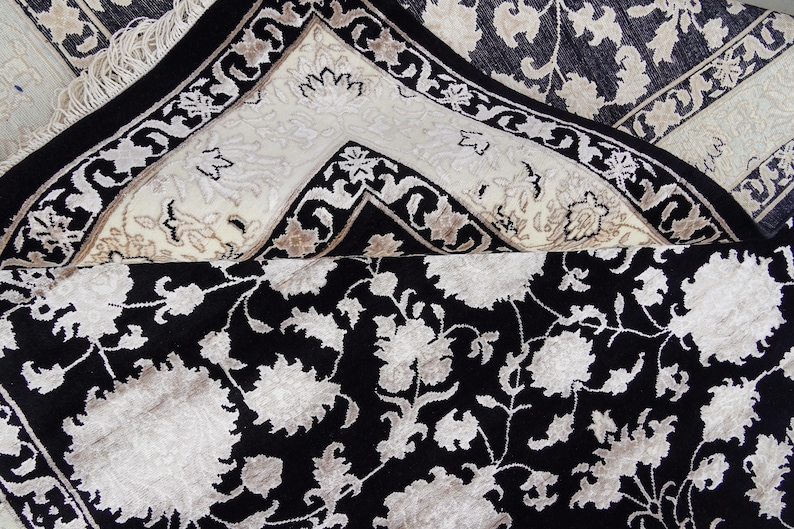 A 5.5x7.9 ft hand-knotted rug featuring a large, ornate ivory and blue central medallion on a deep navy blue field. The field is filled with intricate scrolling vines and small floral motifs. A wide, multi-layered border in ivory and light blue frames the rug. The rug is made of wool with silk highlights that give it a subtle sheen, finished with a short white fringe at the top and bottom.