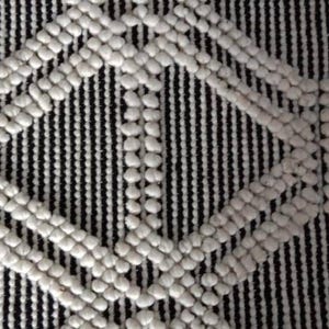 May include: A black and white textured rug with a diamond pattern. The rug is made of woven fabric with raised white circles.Chunky weave wool rug, natural wool rug, mix weave wool rug, boho home decor rug, indoor rug,