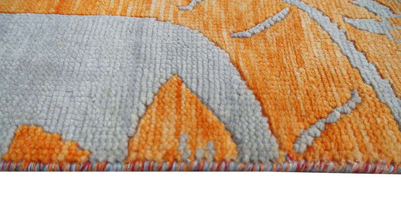 Hand-knotted wool Oushak rug in paisley pattern; rolled samples in teal, blue, orange for a textured floor decor rug.