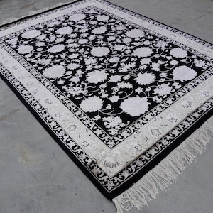 A 5.5x7.9 ft hand-knotted rug featuring a large, ornate ivory and blue central medallion on a deep navy blue field. The field is filled with intricate scrolling vines and small floral motifs. A wide, multi-layered border in ivory and light blue frames the rug. The rug is made of wool with silk highlights that give it a subtle sheen, finished with a short white fringe at the top and bottom.