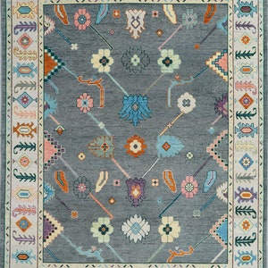 Hand-knotted wool rug in floral Turkish Oushak style, 8x10; blue-gray field with teal, rust, and peach blossoms.