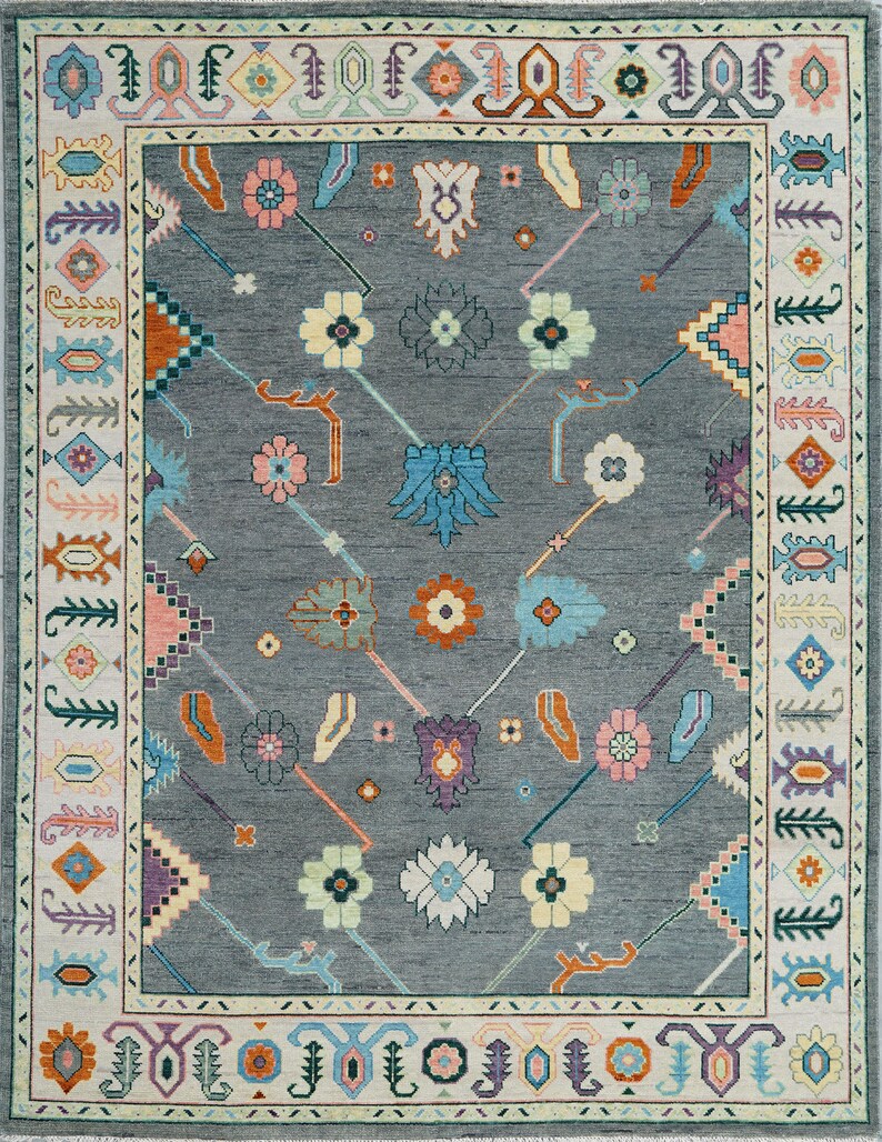 Hand-knotted wool rug in floral Turkish Oushak style, 8x10; blue-gray field with teal, rust, and peach blossoms.