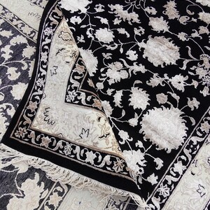 A 5.5x7.9 ft hand-knotted rug featuring a large, ornate ivory and blue central medallion on a deep navy blue field. The field is filled with intricate scrolling vines and small floral motifs. A wide, multi-layered border in ivory and light blue frames the rug. The rug is made of wool with silk highlights that give it a subtle sheen, finished with a short white fringe at the top and bottom.