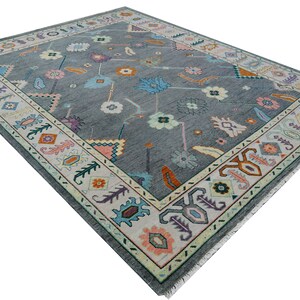 Hand-knotted wool rug in floral Turkish Oushak style, 8x10; blue-gray field with teal, rust, and peach blossoms.