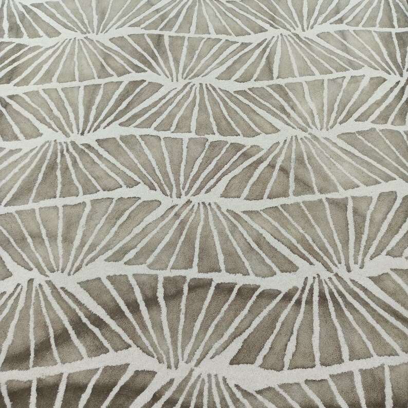 Round hand-tufted wool rug with a vibrant floral pattern in pink, red, orange, and white on a pale background; textured modern living room rug.
