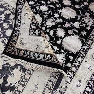 A 5.5x7.9 ft hand-knotted rug featuring a large, ornate ivory and blue central medallion on a deep navy blue field. The field is filled with intricate scrolling vines and small floral motifs. A wide, multi-layered border in ivory and light blue frames the rug. The rug is made of wool with silk highlights that give it a subtle sheen, finished with a short white fringe at the top and bottom.