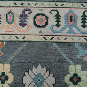 Hand-knotted wool rug in floral Turkish Oushak style, 8x10; blue-gray field with teal, rust, and peach blossoms.