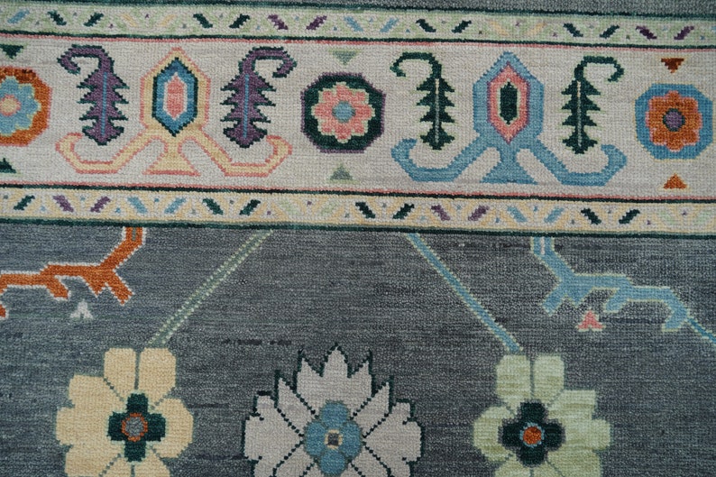 Hand-knotted wool rug in floral Turkish Oushak style, 8x10; blue-gray field with teal, rust, and peach blossoms.