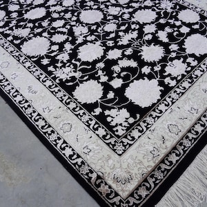 A 5.5x7.9 ft hand-knotted rug featuring a large, ornate ivory and blue central medallion on a deep navy blue field. The field is filled with intricate scrolling vines and small floral motifs. A wide, multi-layered border in ivory and light blue frames the rug. The rug is made of wool with silk highlights that give it a subtle sheen, finished with a short white fringe at the top and bottom.